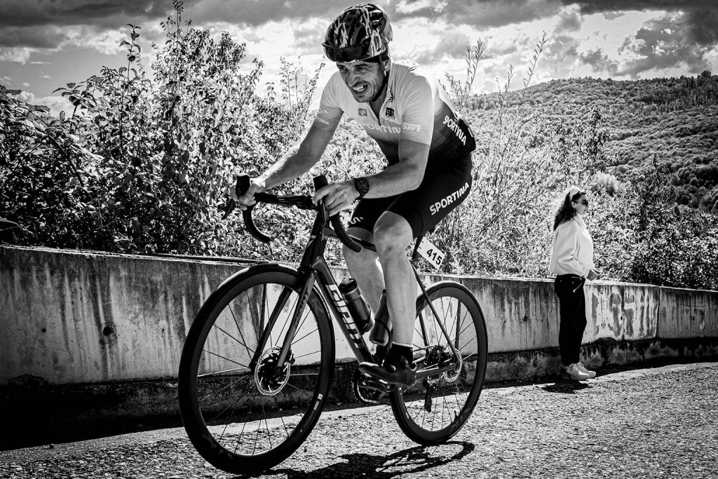 Ciclist participand la cursa The Wall 2025 pe Dealul Sultanul, purtand echipament sportiv si numarul de concurs 415, in efort pe o portiune ascendenta
