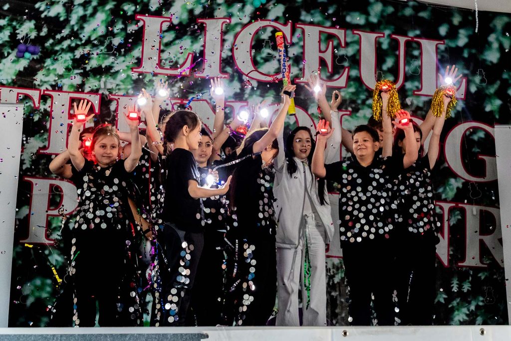 Grup de tineri dansatori pe scena cu costume stralucitoare si confetti, in cadrul probei de dans sportiv Campioni Speciali 2026