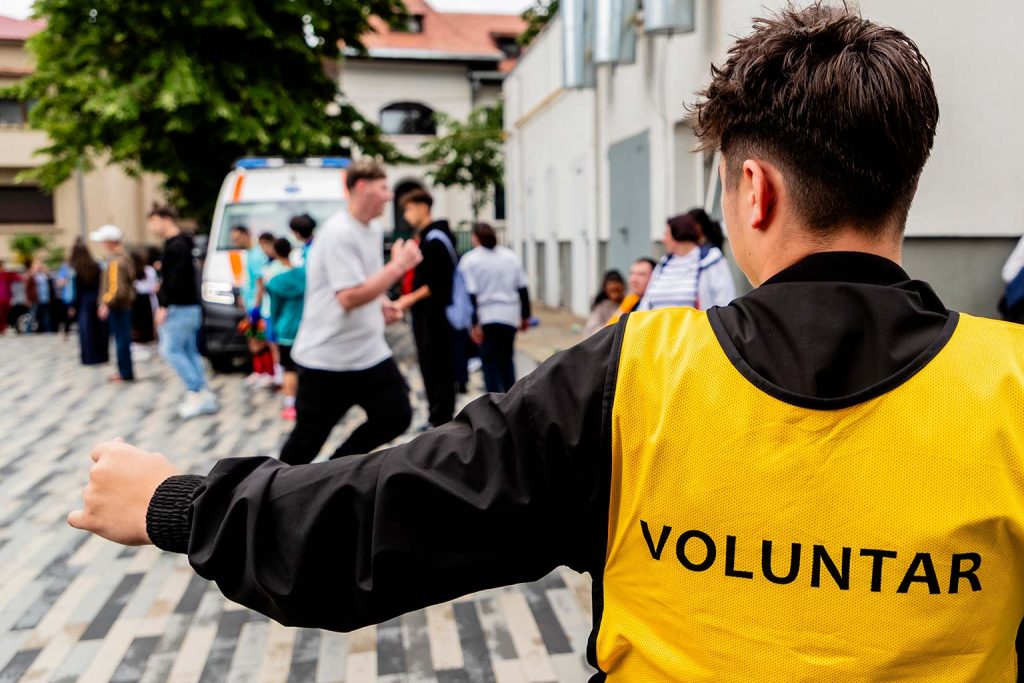 Voluntar in vesta galbena cu inscriptia VOLUNTAR coordonand proba de alergare la Campioni Speciali 2026