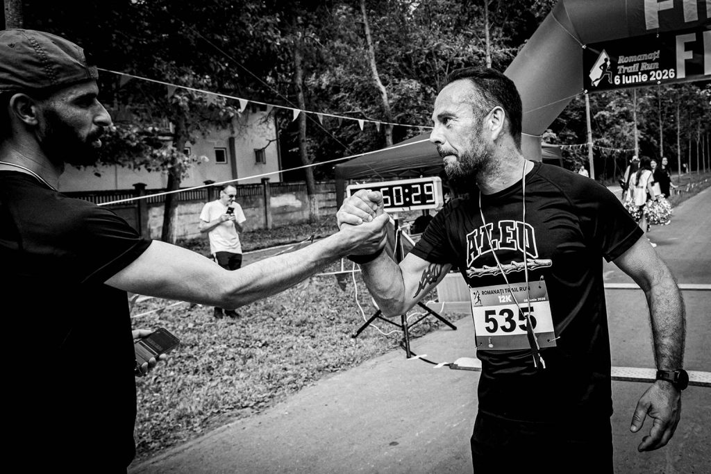 Fotograf sportiv Romanati Trail Run - concurent numar 533 felicitat dupa finish proba 12km, moment de camaraderie si respect