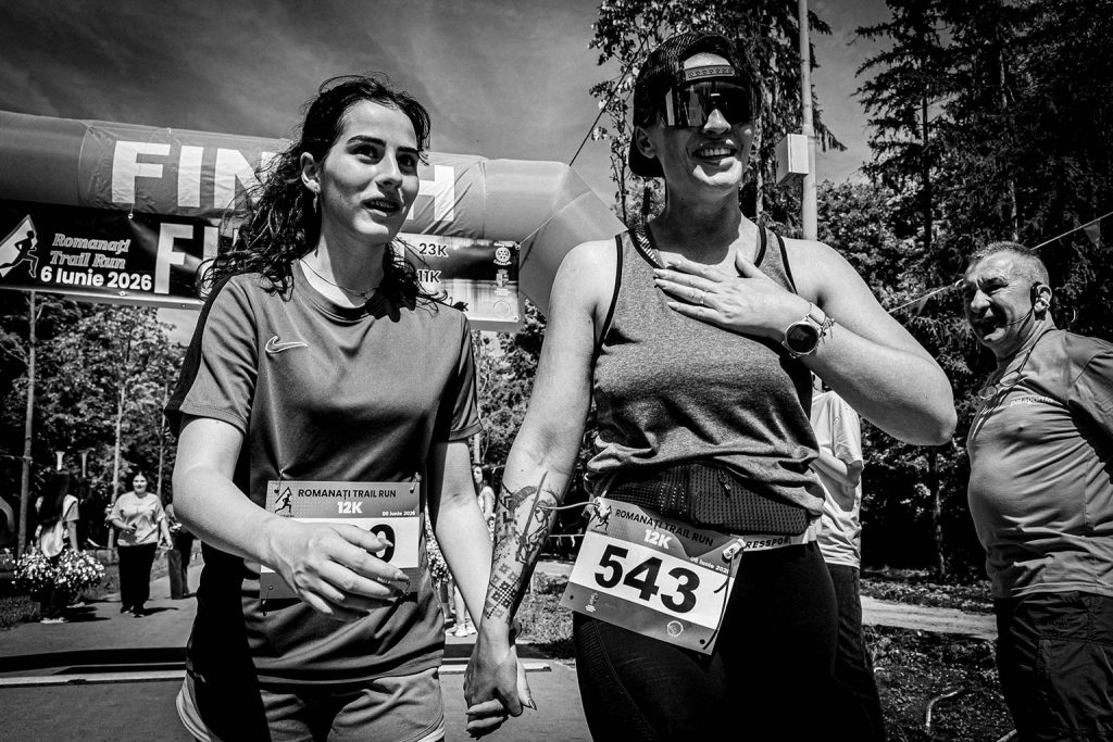 Fotograf sportiv Romanati Trail Run - doua alergatoare tinandu-se de mana la finish proba 12km, numar 543, spirit de echipa