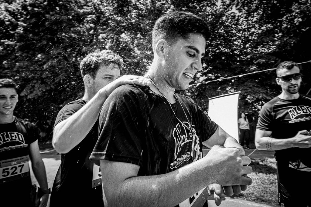 Fotograf sportiv Romanati Trail Run - concurent felicitat de colegi dupa finish proba 23km, moment de camaraderie echipa Aleo