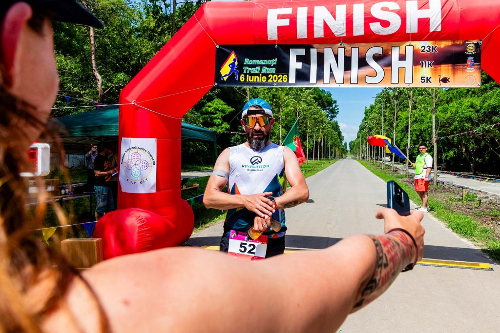 Fotograf sportiv Romanati Trail Run - concurenta dupa proba de 12km facand fotografie la arcada de finish, asteptandu-si sotul de la proba de 23km