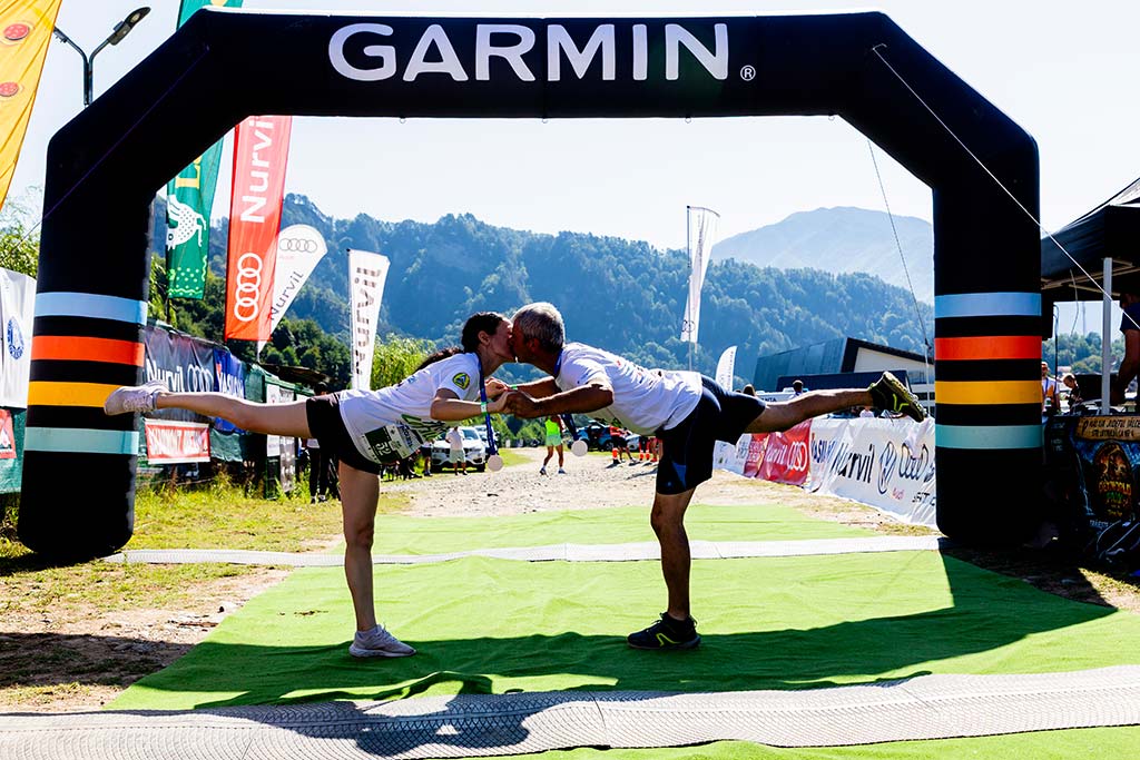 Cuplu de atleti sarutandu-se sub arcul Garmin la finish-ul cursei.