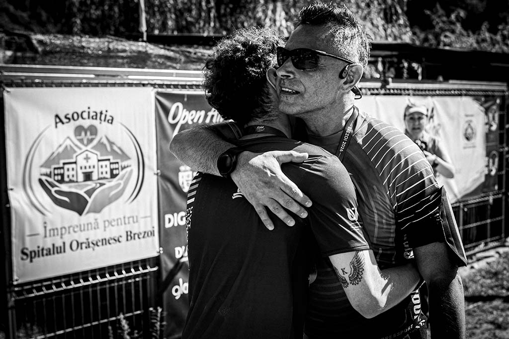 Fotografii emotionante - imbratisare intre tata si fiu la final de cursa sportiva.