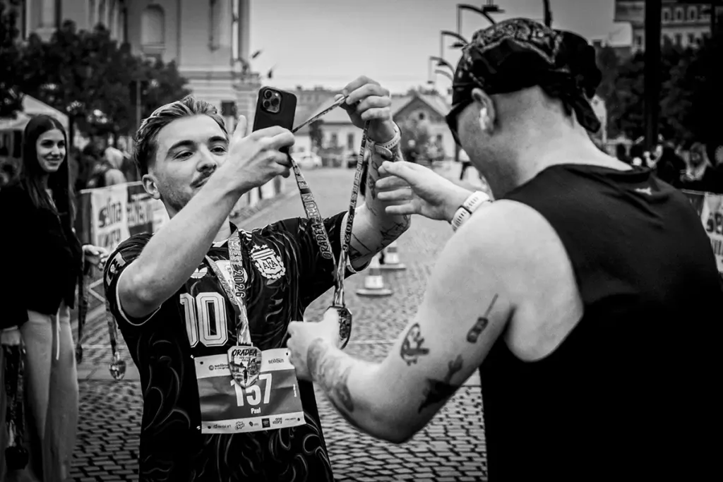 Concurent cu numarul 157 ii inmaneza medalia de finisher prietenului sau, surprins de fotograf sportiv.